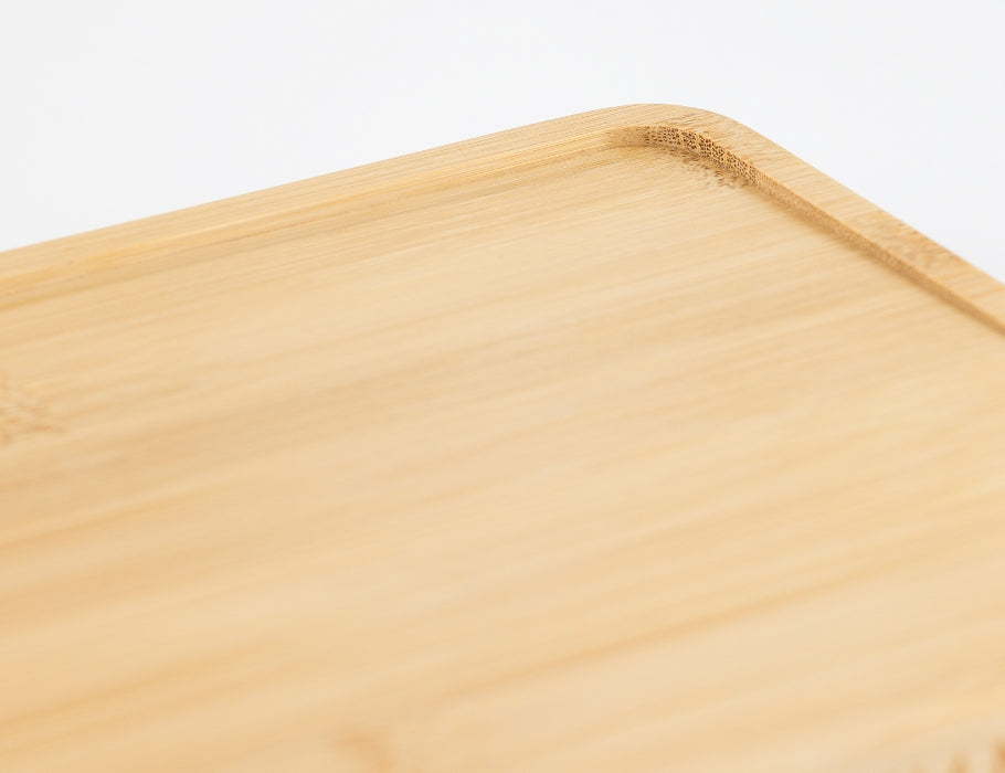 Close-up van de hoek van een Namture bamboe snijplank met sapgeul en afgeronde randen.