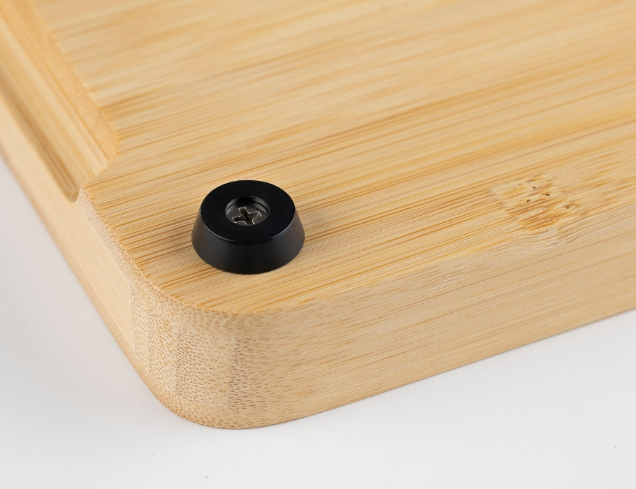 Close-up van de onderkant van een Namture bamboe snijplank met een zwart antislip voetje en afgeronde hoeken.