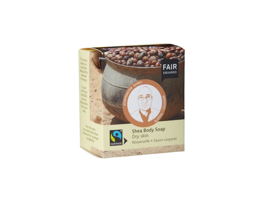 Fair Squared Shea Body Soap in een beige doosje met afbeelding van sheanoten en een illustratie van zeepmaker Khiro; geschikt voor droge huid en Fairtrade-gecertificeerd.