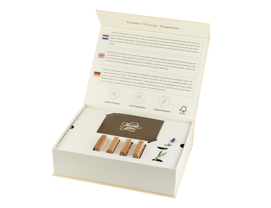 Open cadeauverpakking van de Namture acaciahouten snijplankenset, met duurzaamheidsinformatie aan de binnenkant van het deksel en een kaartje en accessoires in het inzetvak.