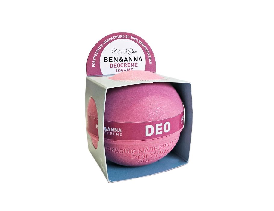 Roze Ben & Anna deodorantbal van composteerbare PolyPotato®-verpakking, gepresenteerd in een open kartonnen doos met roze en blauwe accenten; de ronde deo is volledig zichtbaar vanuit de voorkant.