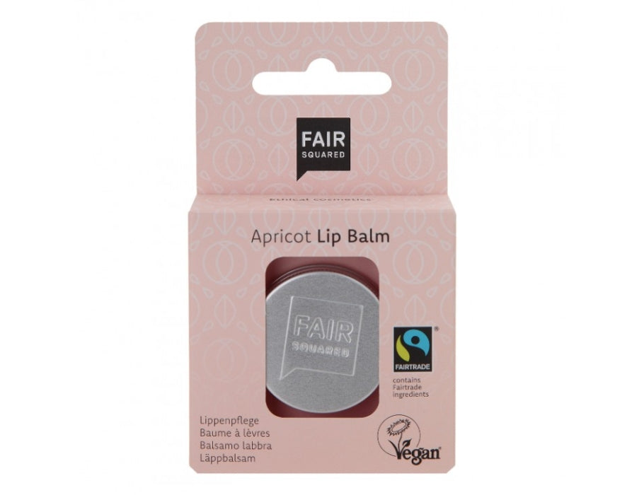 Fair Squared Apricot Lip Balm in een zilverkleurig blikje, verpakt in een lichtroze kartonnen doosje met abrikoospatroon; Fairtrade en vegan gecertificeerd.
